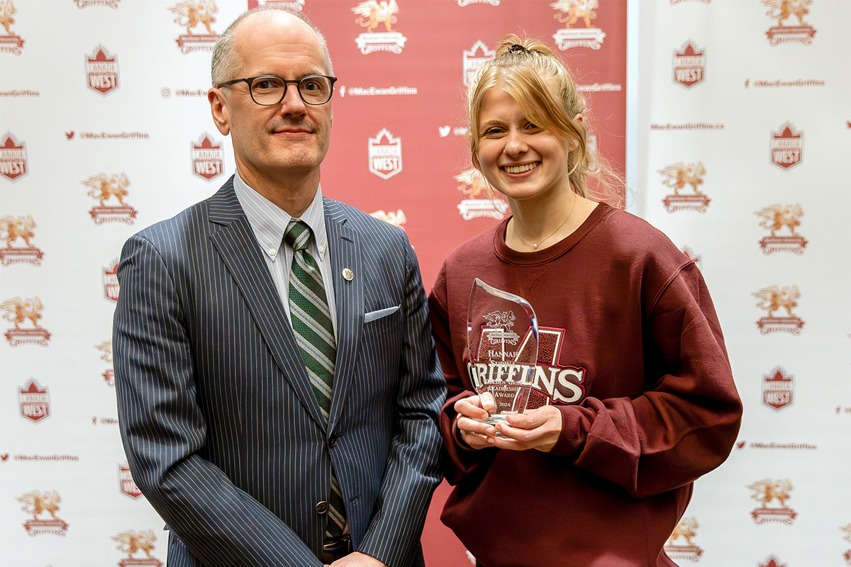 Dr. Craig Monk stands with Hannah Supina, who holds her Leadership Award.