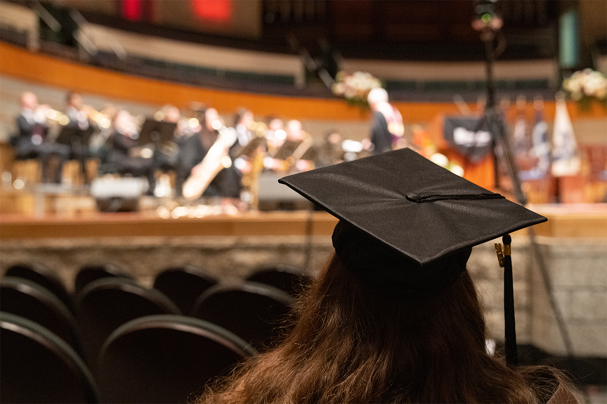A grad seen from behind watching the convocation ceremony