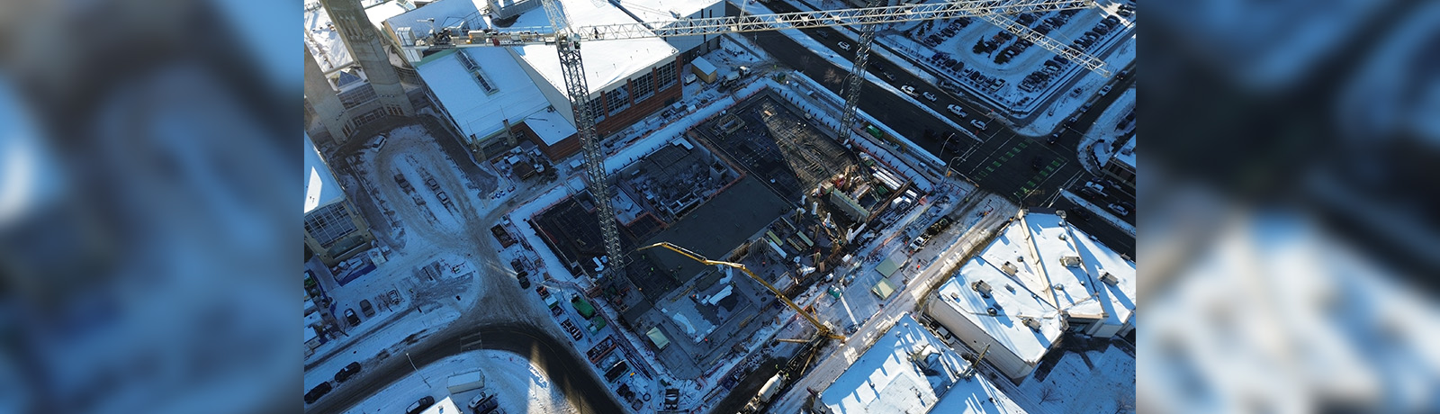 An aerial view of two cranes over the work site at the coming School of Business Building.