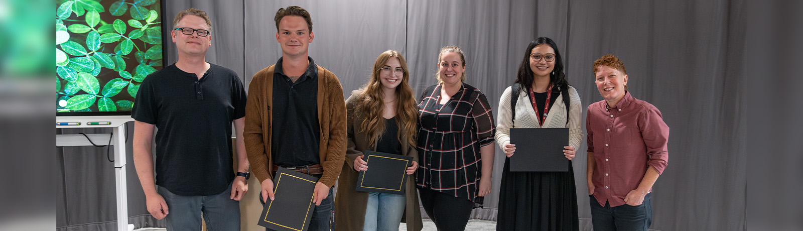 Taylor Arnell holds her certificate for her second-place win at Alberta Innovates, standing with two other students and three faculty mentors.