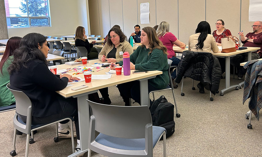A classroom filled with child and youth professionals work on an activity together