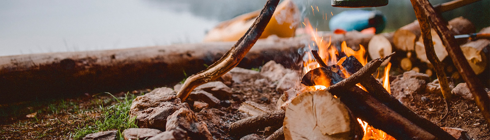 A campfire with a body of water in the background