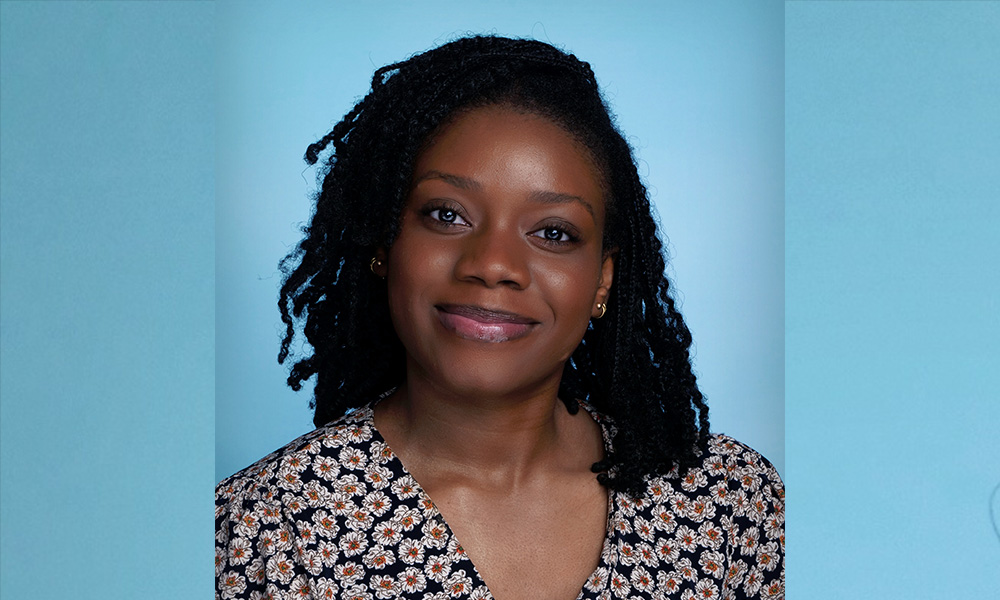 A headshot of Jennifer Onwuegbule smiling against a blue backdrop