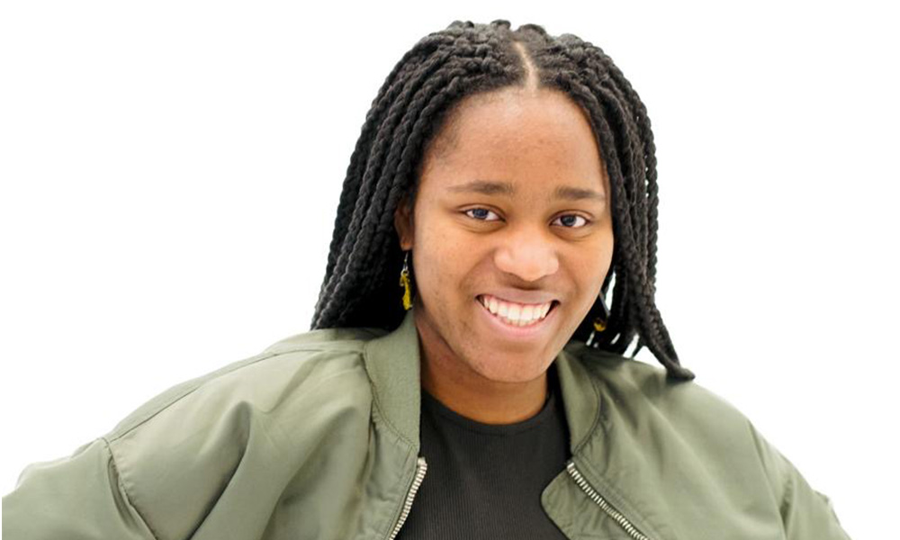 A headshot of Uche Osineme against a white background wearing a black jacket. 