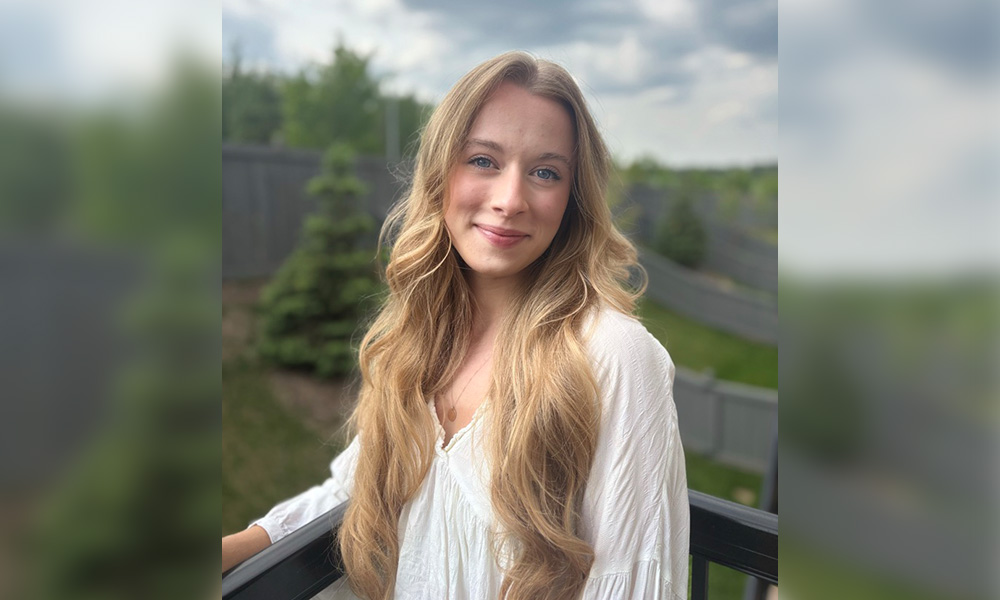 a woman leaning against a patio railing in a backyard