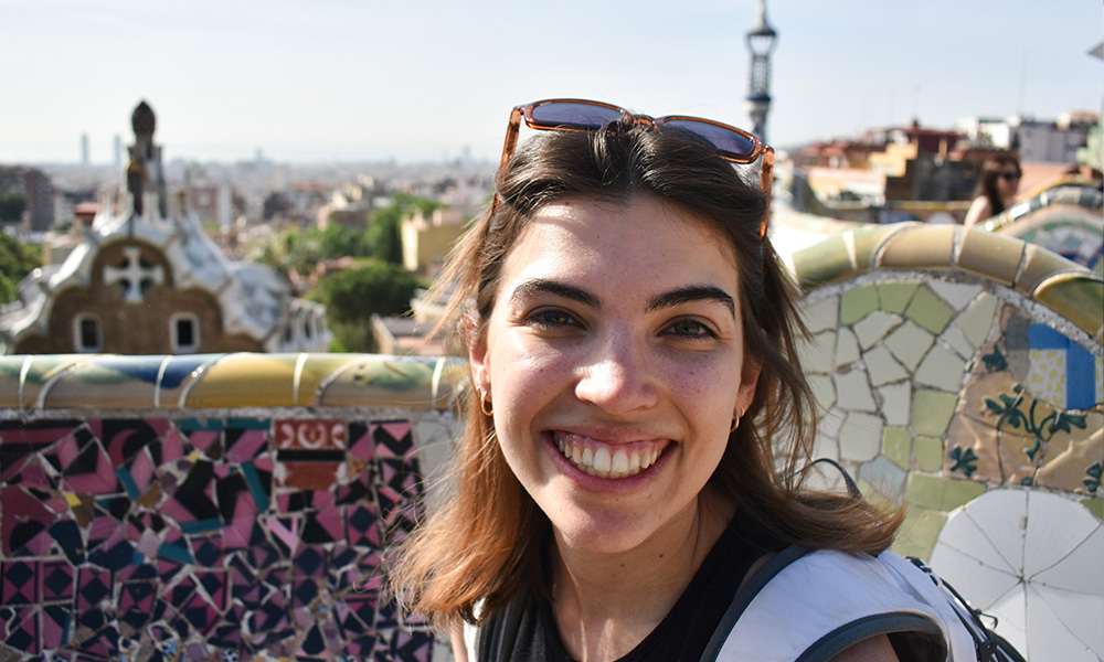 a woman smiles at a camera, taking a selfie