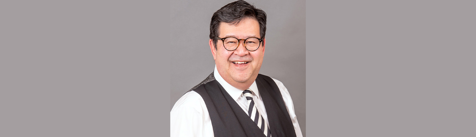 A headshot of Gary Mar in front of a grey background.