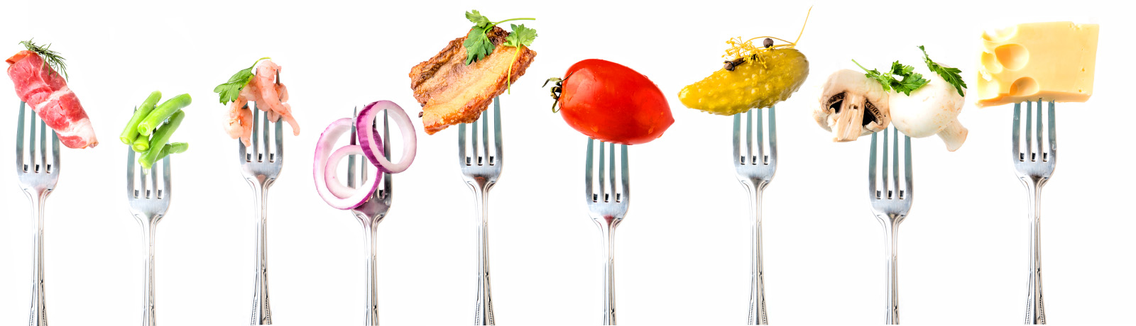A series of forks with different food items on them – cheese, meat, fruit, vegatables