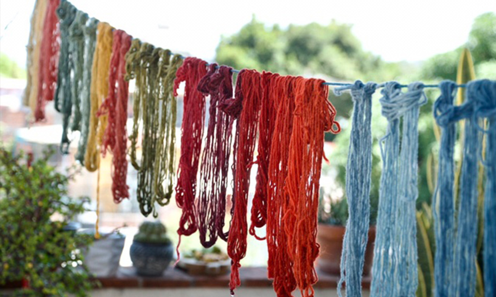 Colourful dyed textiles hang to dry on a line