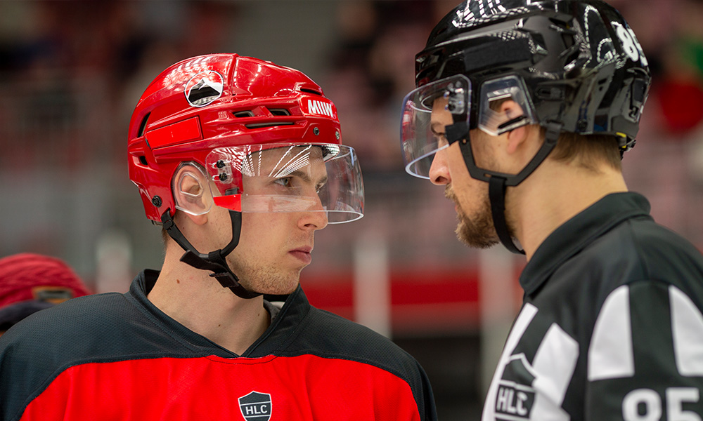 A hockey player and a ref stand nose-to-nose