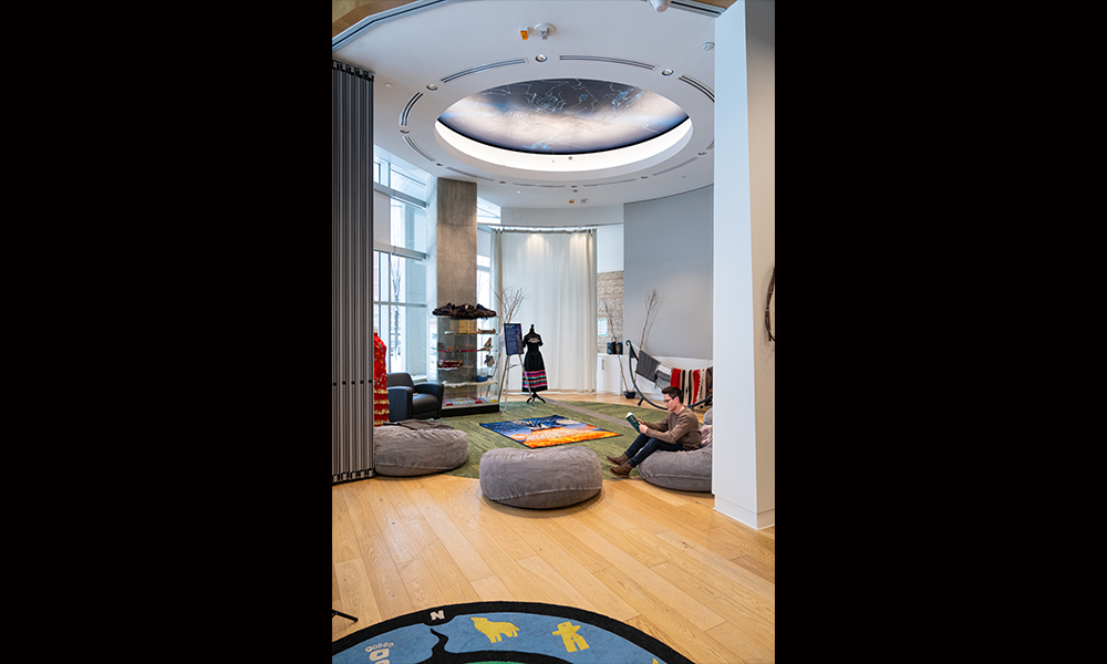 a student sits on a beanbag reading, at the edge of a circular room
