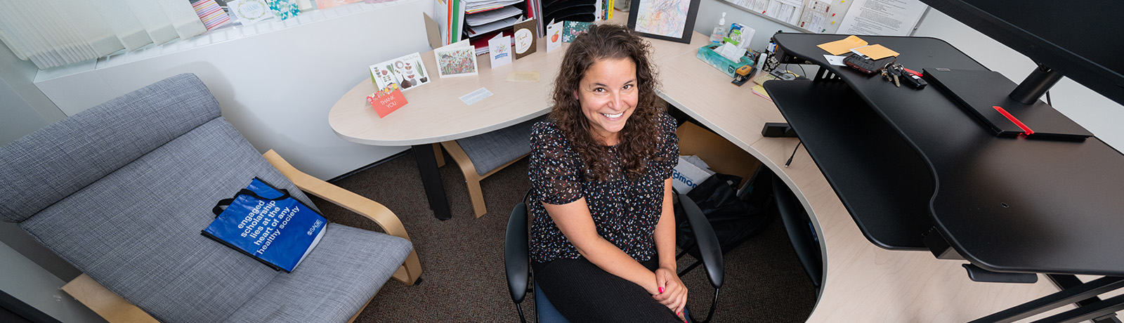 Dr. Amanda Nelund looks up at the camera while seated at her desk
