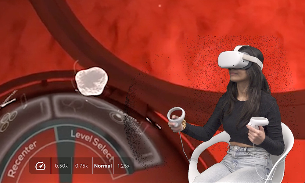 A woman sits in a chair wearing virtual reality googles with the animation of a heart that she's seeing through the glasses behind her