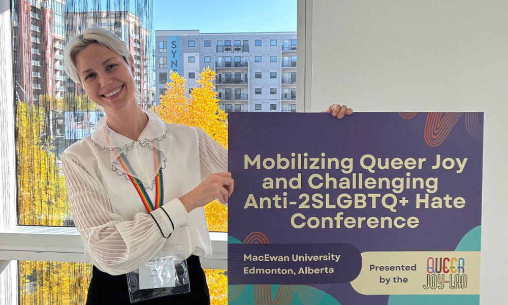 Dr. JJ Wright holds up a sign with conference information.