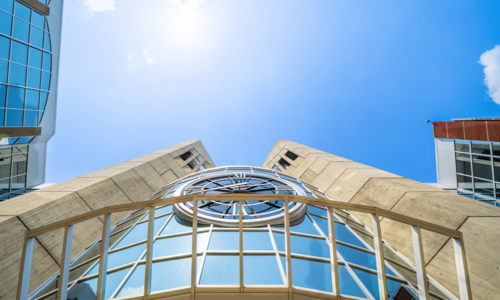 A view straight up the clock tower, with a light blue sky beyond.