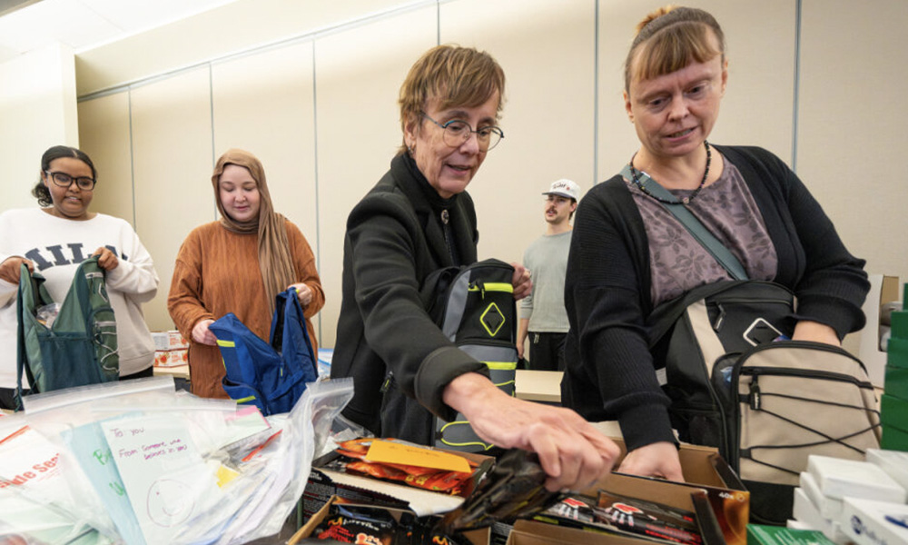 Volunteers grab supplies to put into backpacks