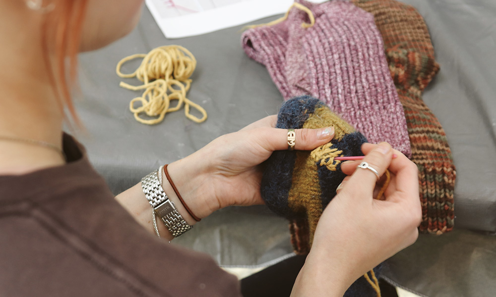 Close up of a person's hands stitching socks