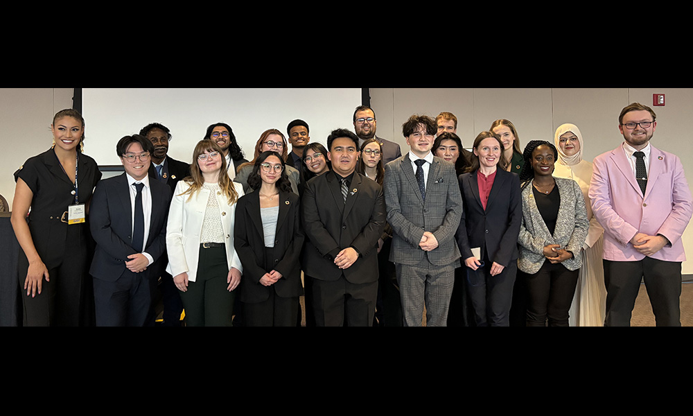 A group of students stand together against a white background