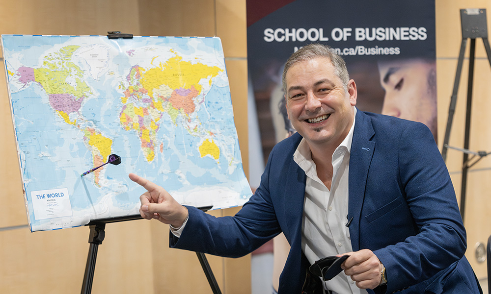 Sorin Mihailovici points at a map of the world