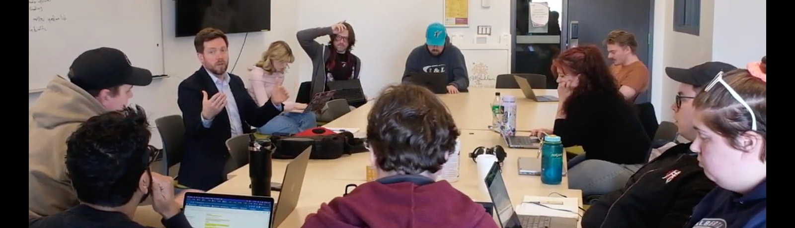 Dr. Steve Lillebuen and students sit around a table discussing their work