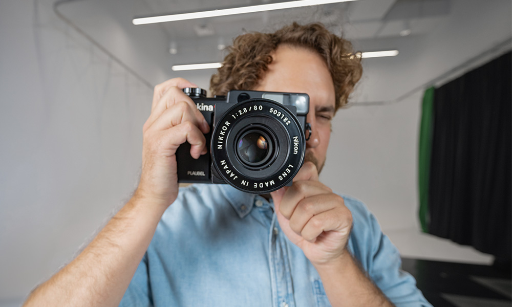 Waugh looks through the viewfinder of a large-format camera