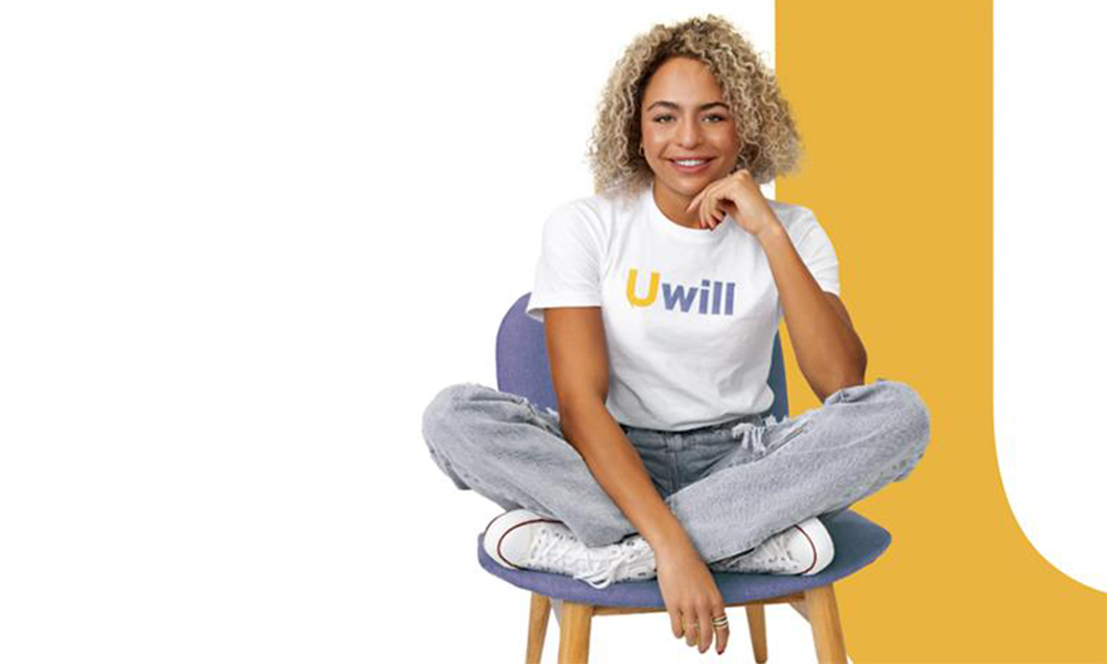 A woman sitting in a chair cross-legged with her chin in one hand