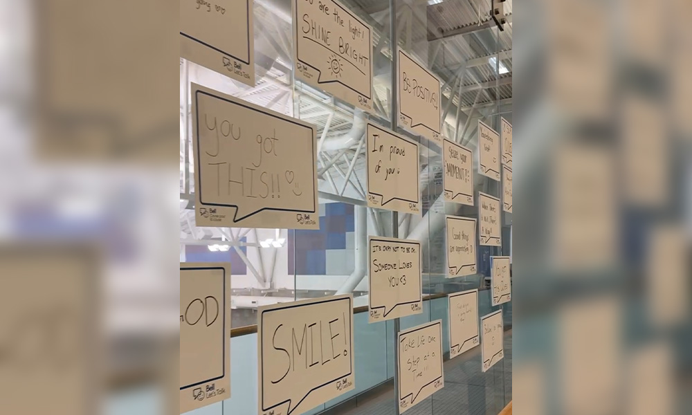 Signs with encouraging messages are taped to the glass pedway wall behind the pool.