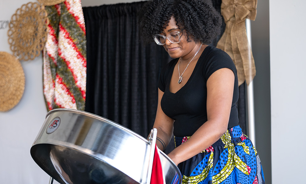 A woman plays a steel drum