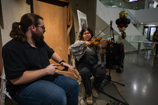 Ethan Graves plays the spoons alongside Brianna Lizotte on the fiddle