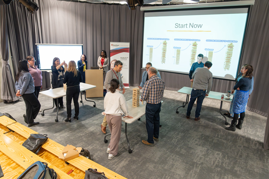 Groups of participants work together on a jenga-style challenge