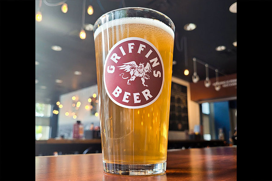 A glass of beer with the "Griffins Beer" logo