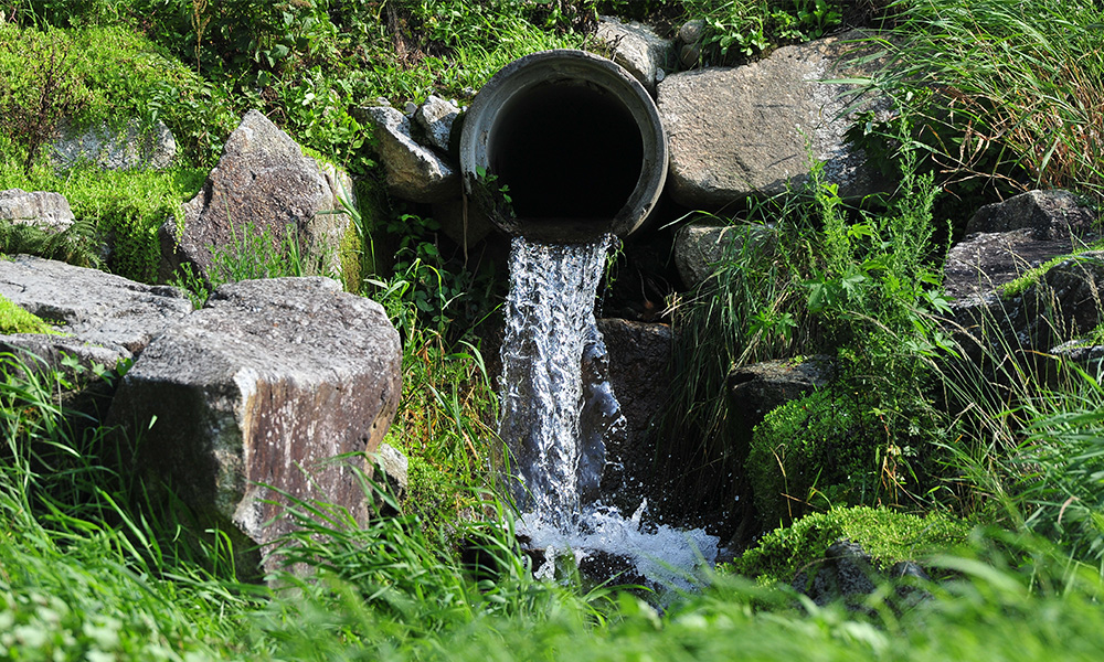 A pipe drains water into a stream.