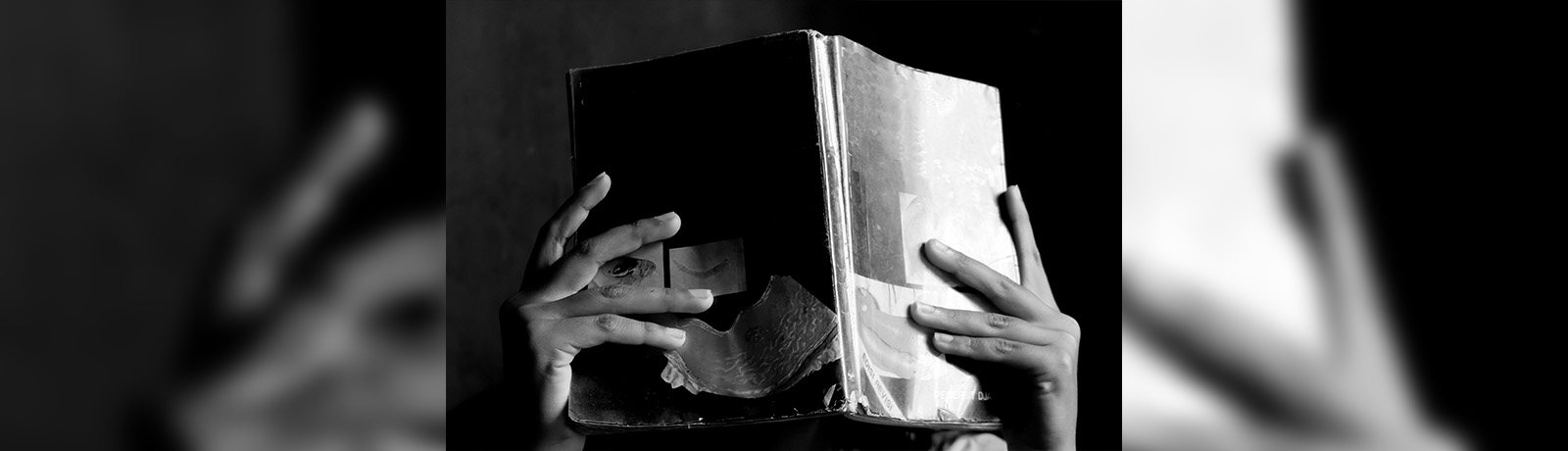 A pair of hands of a young woman reading a book.