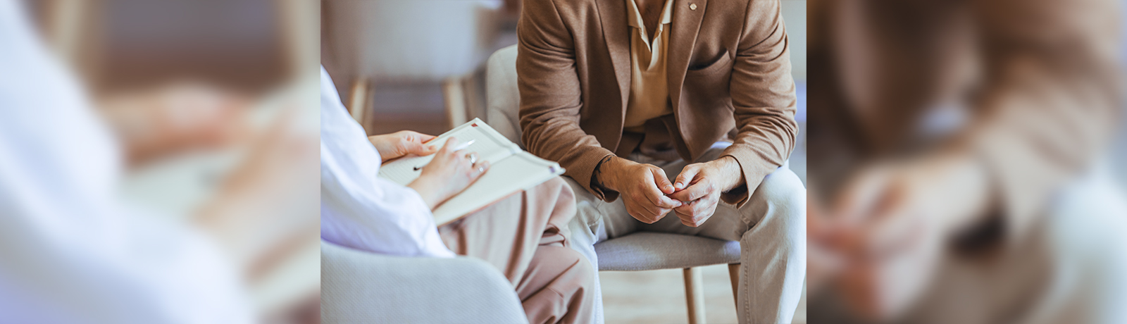 two people sitting facing each other and only their torso and legs are visible.