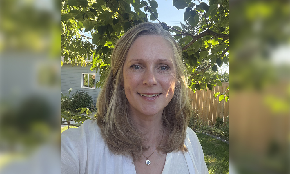 a selfie photo of a woman in a backyard under a tree on a sunny day