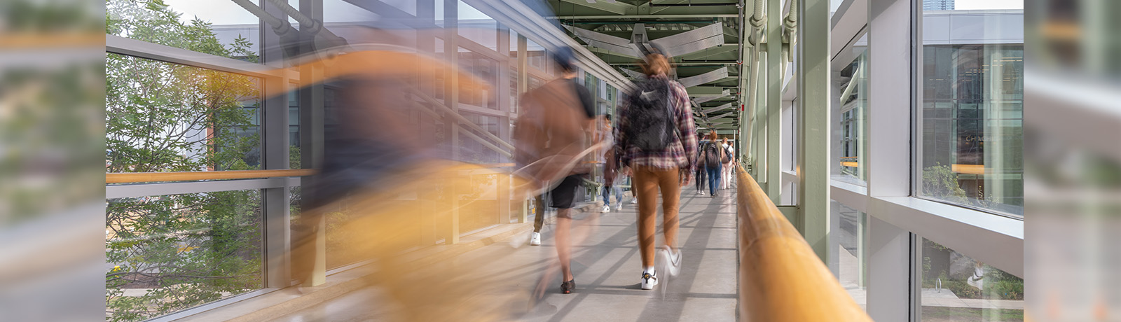 Blurred image of students crossing a pedway on campus