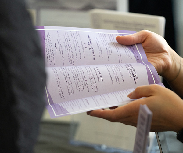 close up of someone handing another person a brochure