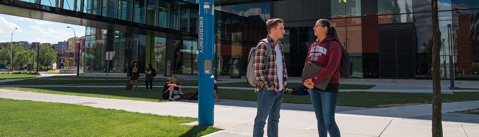 students standing outside by emergency post