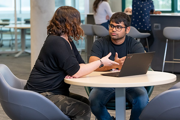 two students speaking to each other over a laptop