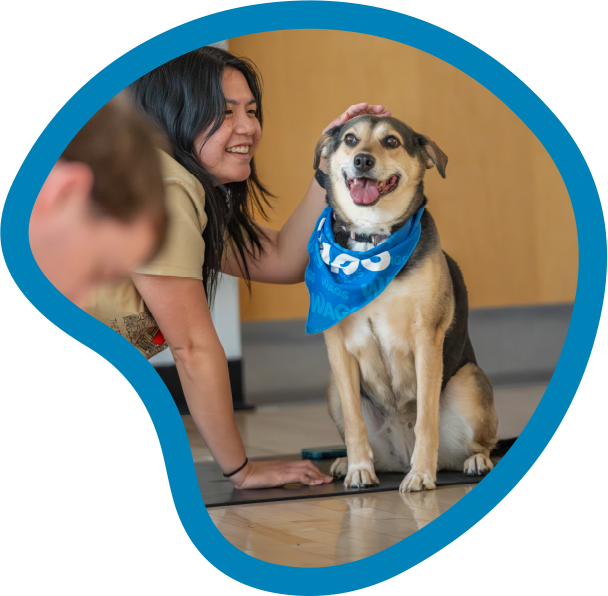 student petting a dog in yoga class