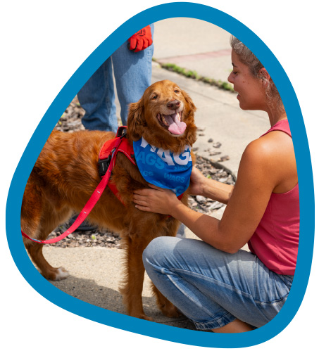 female petting a WAGS dog outside