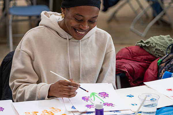 female student at the Art Buffet painting with dog paw print