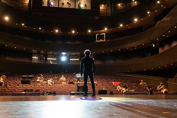 male student standing on stage at the Triffo Theatre