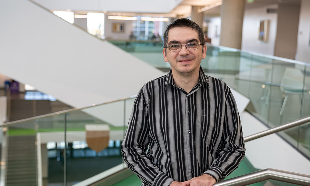 Dr. Nicolae Strungaru stands in front of the stairs in Allard Hall