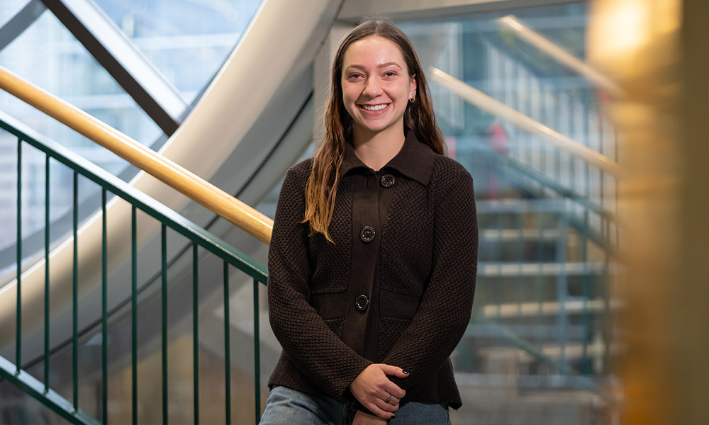 Jessalyn LeBlanc stands in front of the clock tower in the library