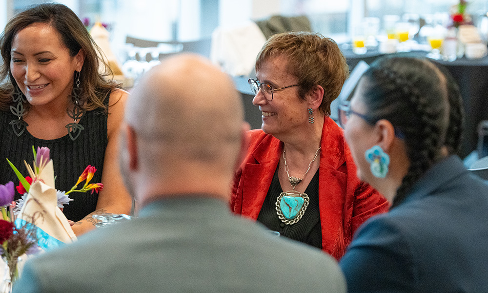 Dr. Trimee sits with guests at a table