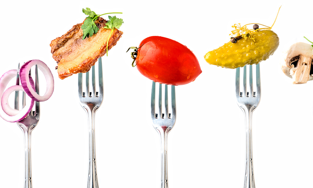 Forks in a row all with different types of food skewered on them