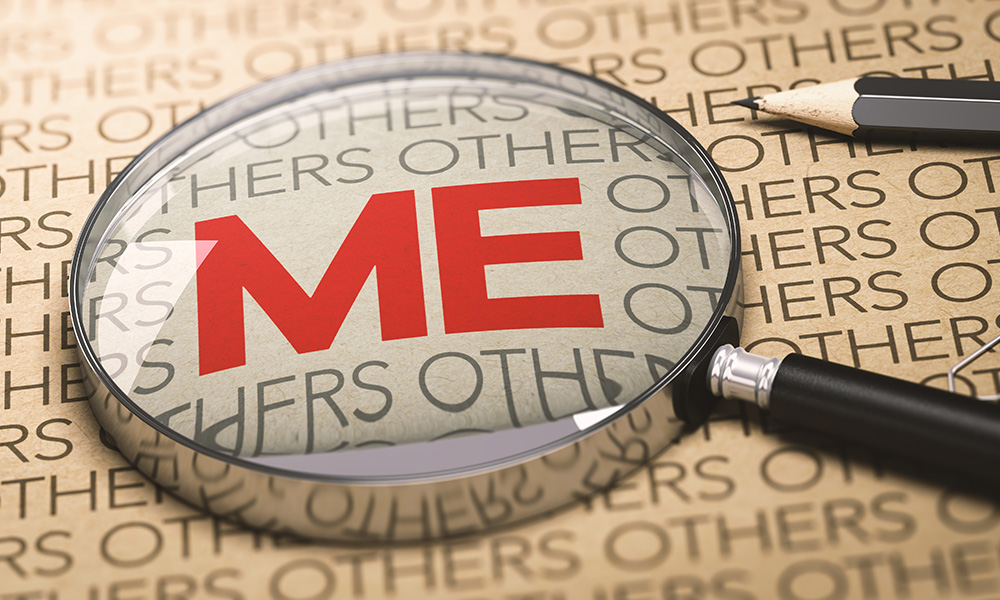 A magnifying glass over a giant red "ME" among a page of "others"
