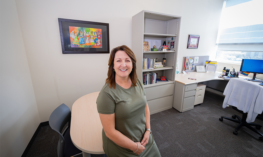 Christine Pope sits at her desk