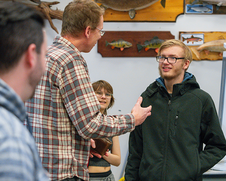 male student speaking to teacher in classroom at Open House